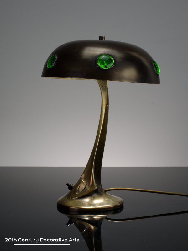 A bronze jugendstil / secessionist bronze table lamp, Austria circa 1900, the stylised bronze base supporting a dome shade inset with green glass cabochons