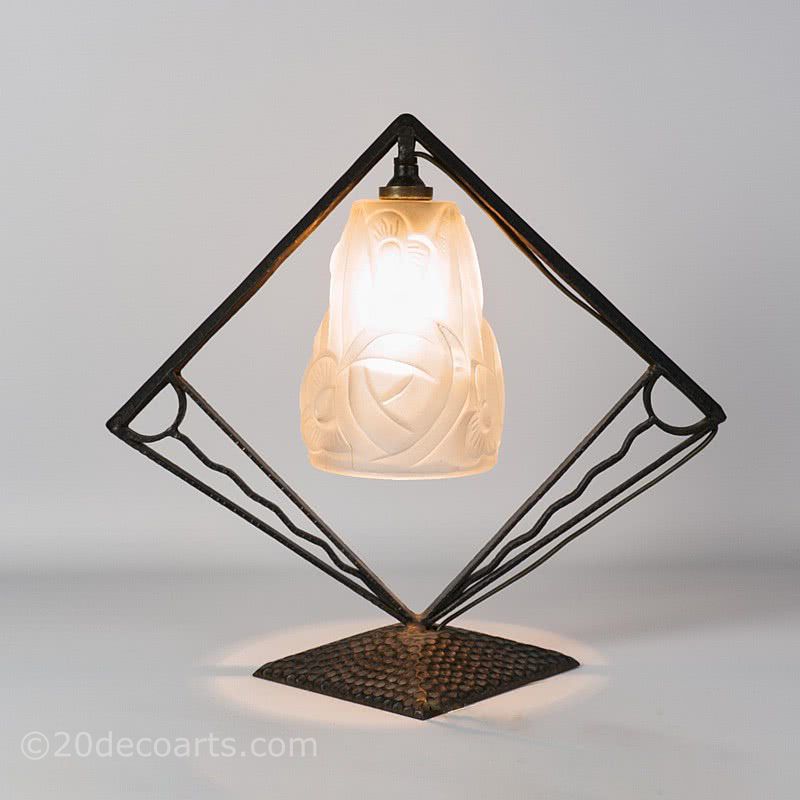  20th Century Decorative Arts | A wrought iron art deco lamp with shade by Degue, circa late 1920's, the stylised frame supporting the frosted shade