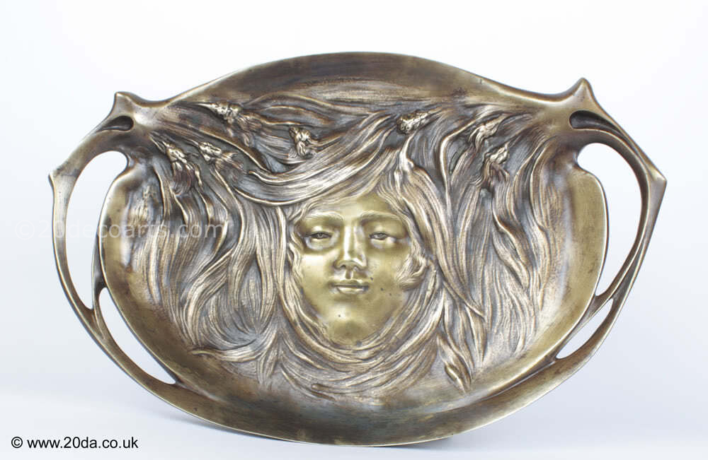  20th Century Decorative Arts |An Art Nouveau bronze dish/plaque, circa 1900, France the patinated bronze featuring a typical "femme fleur".