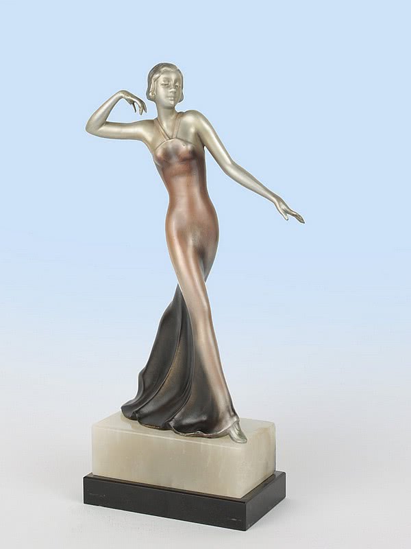  20th Century Decorative Arts |A stylish Art Deco spelter figure attributed to Lorenzl, c1930, Austria the elegant young woman dressed in evening dress, the spelter cold-painted silver with enamelled details, mounted on a marble and alabaster base