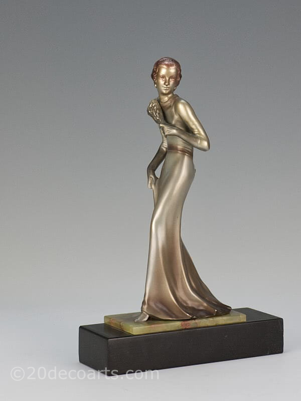  20th Century Decorative Arts | A rare Art Deco  Austrian bronze  figure by Josef Lorenzl,  circa 1930 depicting a stylish lady in evening attire with a lacquered silver and enamelled cold-painted finish, mounted on a shaped green onyx and black marble base-