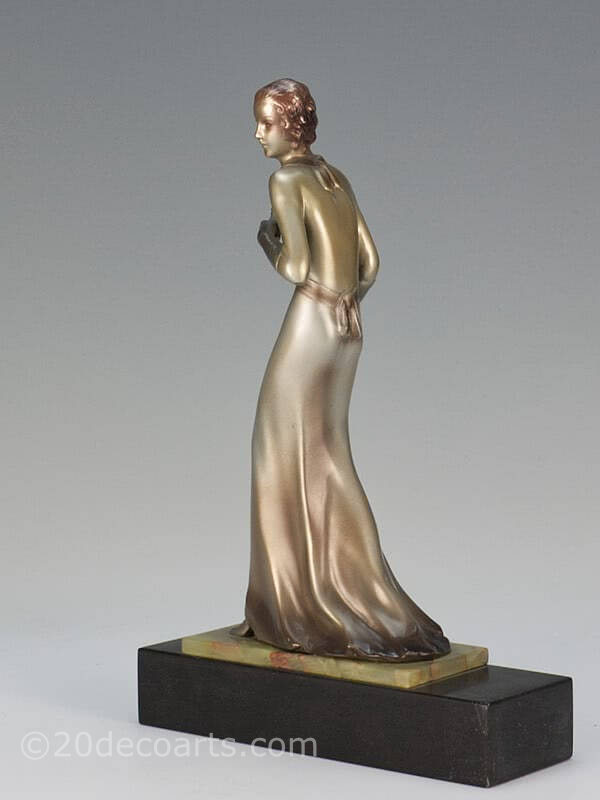  20th Century Decorative Arts | A rare Art Deco  Austrian bronze  figure by Josef Lorenzl,  circa 1930 depicting a stylish lady in evening attire with a lacquered silver and enamelled cold-painted finish, mounted on a shaped green onyx and black marble base-
